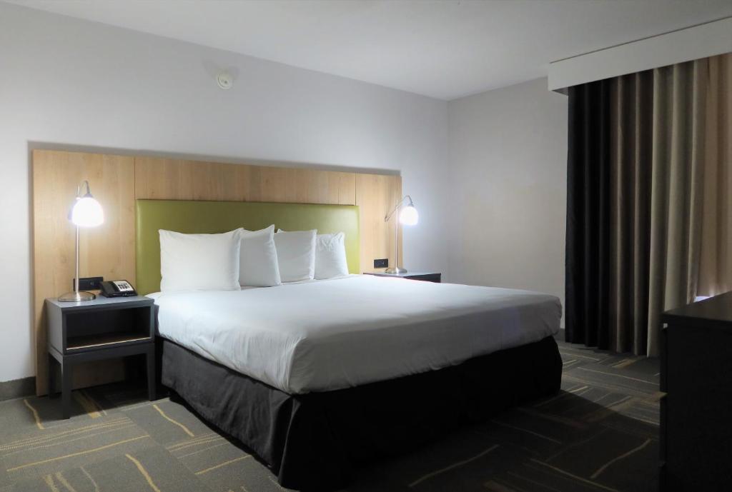 凤凰城格林豪泰凤凰城天港机场套房酒店的酒店客房设有一张大床和一台电视。