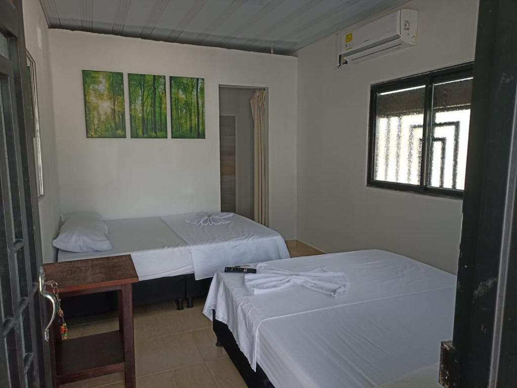 特里温福港Alojamiento la esmeralda的客房设有两张床和窗户。