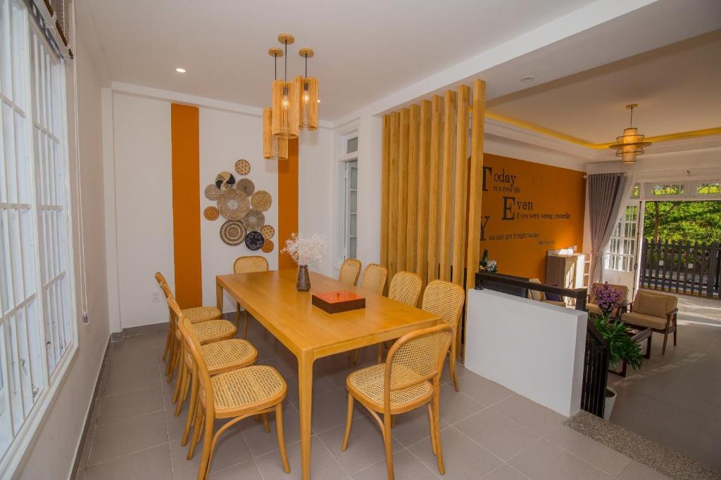 大叻Suri Homestay的配有木桌椅的餐厅