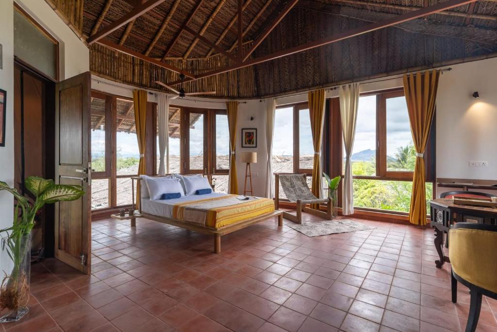 蒂鲁瓦纳马莱Gia Mantra Eco Resort/stay的一间设有床铺的卧室,位于带窗户的房间内