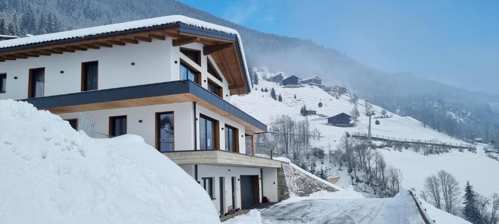 维尔德科格尔山麓布兰贝格Apartment Talblick的一座有雪盖屋顶的山中建筑