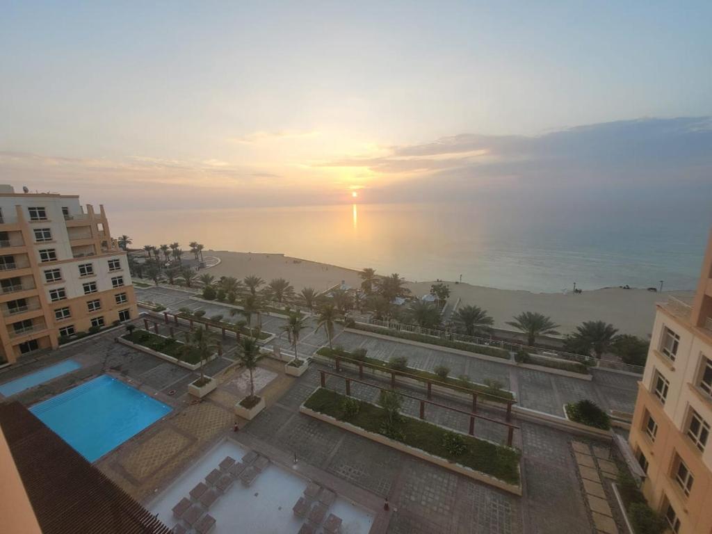 阿卜杜勒国王经济城Royal Beach Apartment的享有带游泳池和海洋的建筑的空中景致