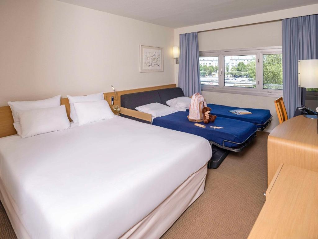 南特诺富特南特中心火车站酒店的酒店客房设有两张床和窗户。