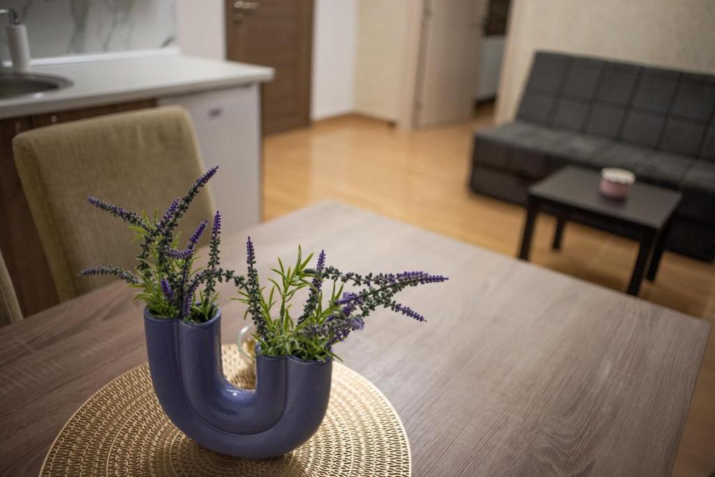 沙巴茨La Mirage的一张桌子,上面有两只蓝色花瓶,上面有紫色的花
