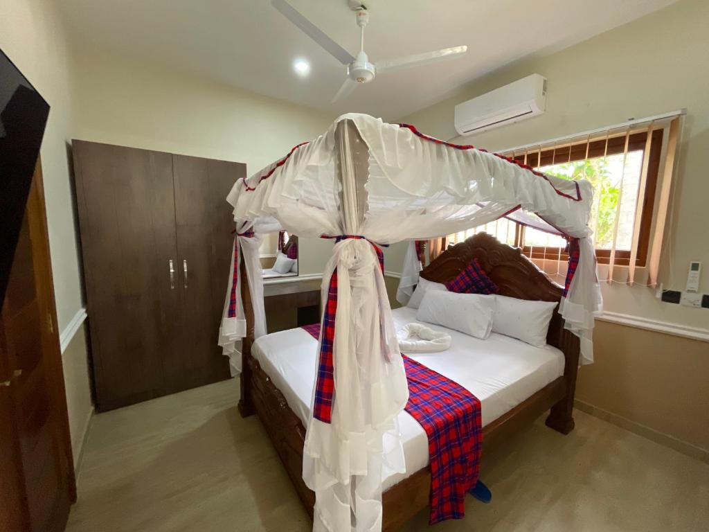 蒙巴萨Maasai Koroga的一间卧室配有一张带天蓬的床