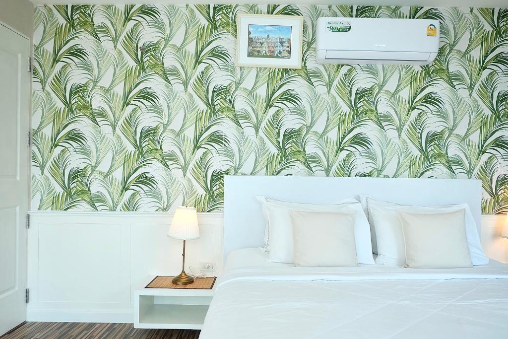 邦盛The Beach Bangsaen by Thanthita next to Wonnapa beach的卧室配有白色床和绿色白色壁纸
