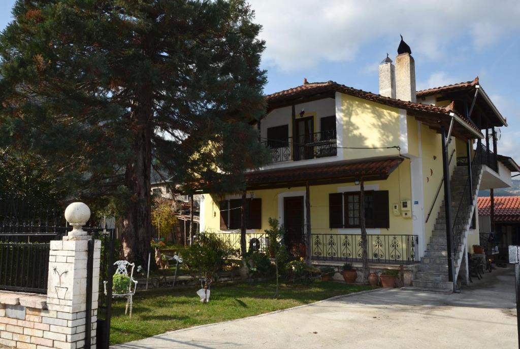 GraviáΣοφίτα的前面有一棵树的黄色房子