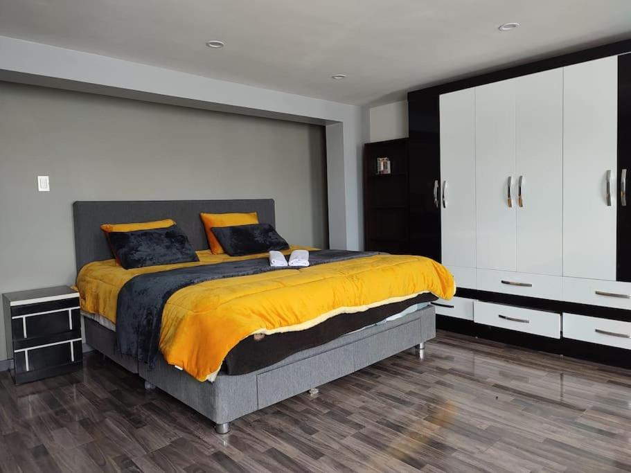 普诺departamento independiente的一间卧室配有一张带黄色床单的大床