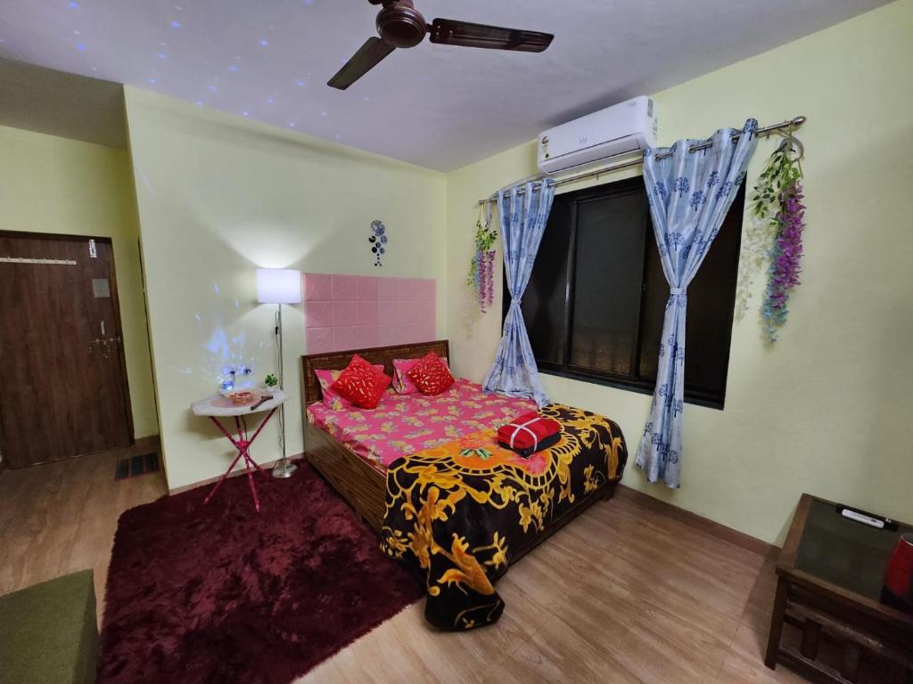 阿利鲍格Bhumi Holiday Home的一间卧室配有一张带红色枕头的床和一扇窗户