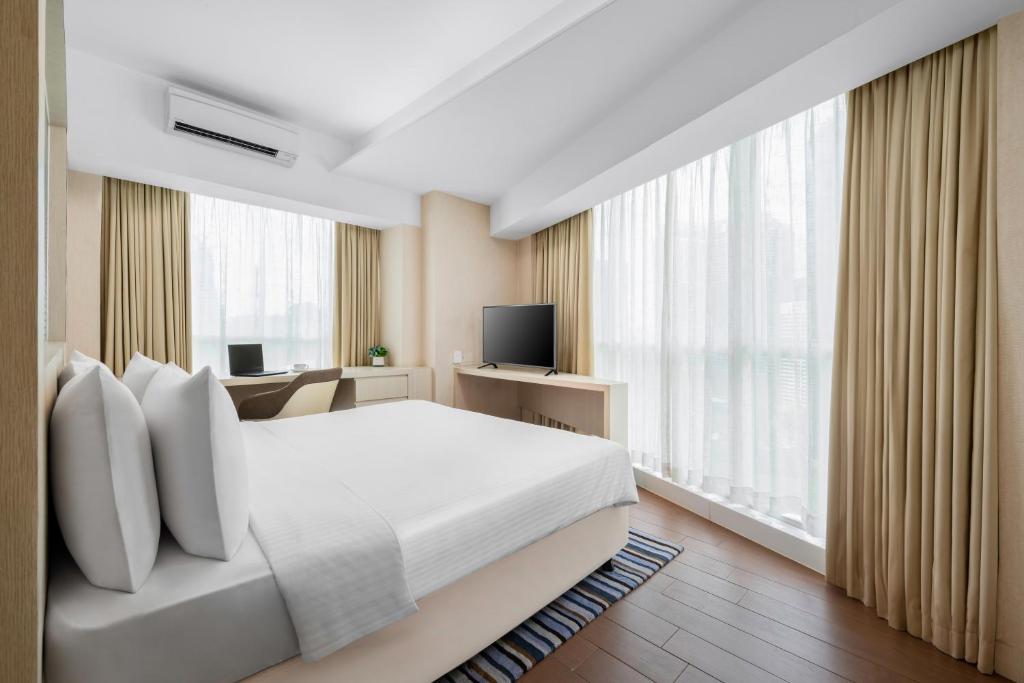 吉隆坡吉隆坡豪亚酒店式公寓 - 远东酒店集团旗下的卧室配有白色的床和电视。