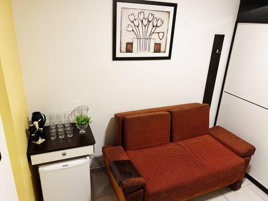 巴乌鲁Flat próx. a USP e Nações Unidas的客厅配有棕色沙发和桌子