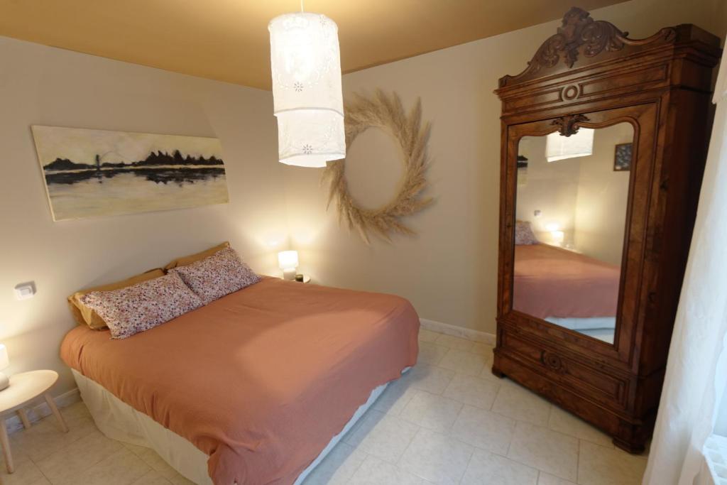 Saint-Dyé-sur-LoireLa Boisselée的一间卧室配有一张床和一面大镜子