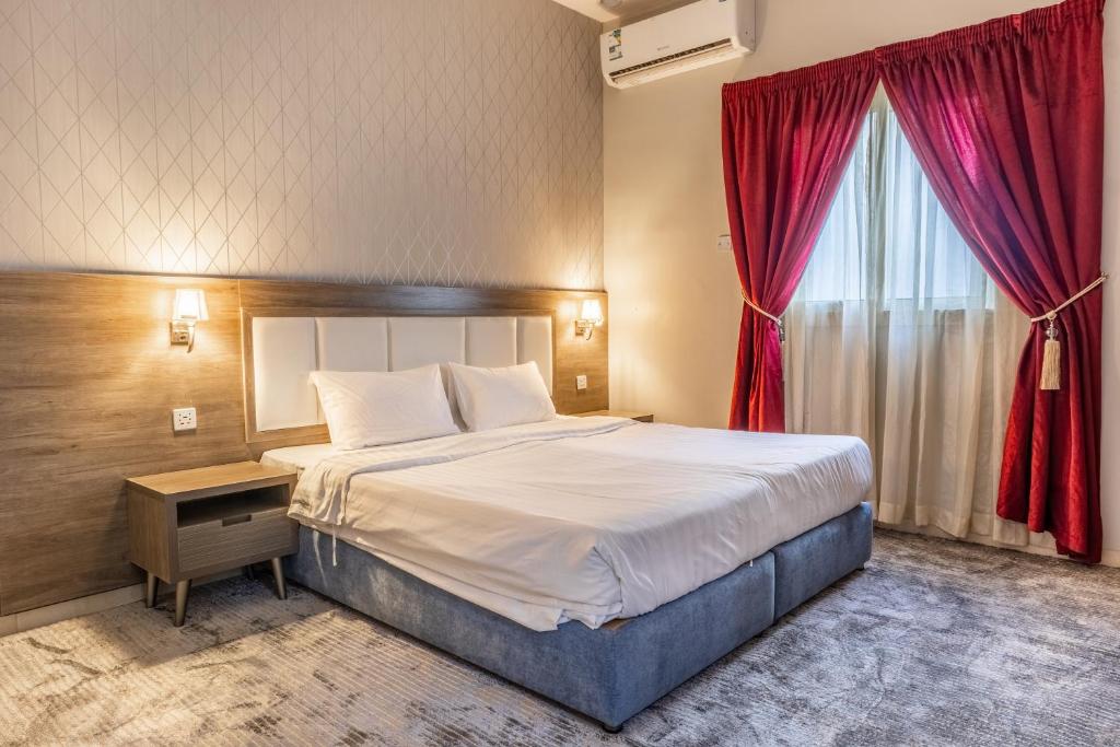 麦地那Modern Family Apartments 7 Mins Drive to Al Masjid Nabwi - Al Jamawat的一间卧室设有一张大床和红色窗户。