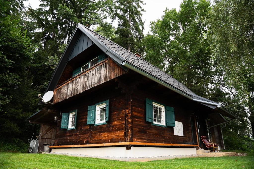 EdelschrottGregor's Ferienhaus im Wald的小木屋设有绿色百叶窗