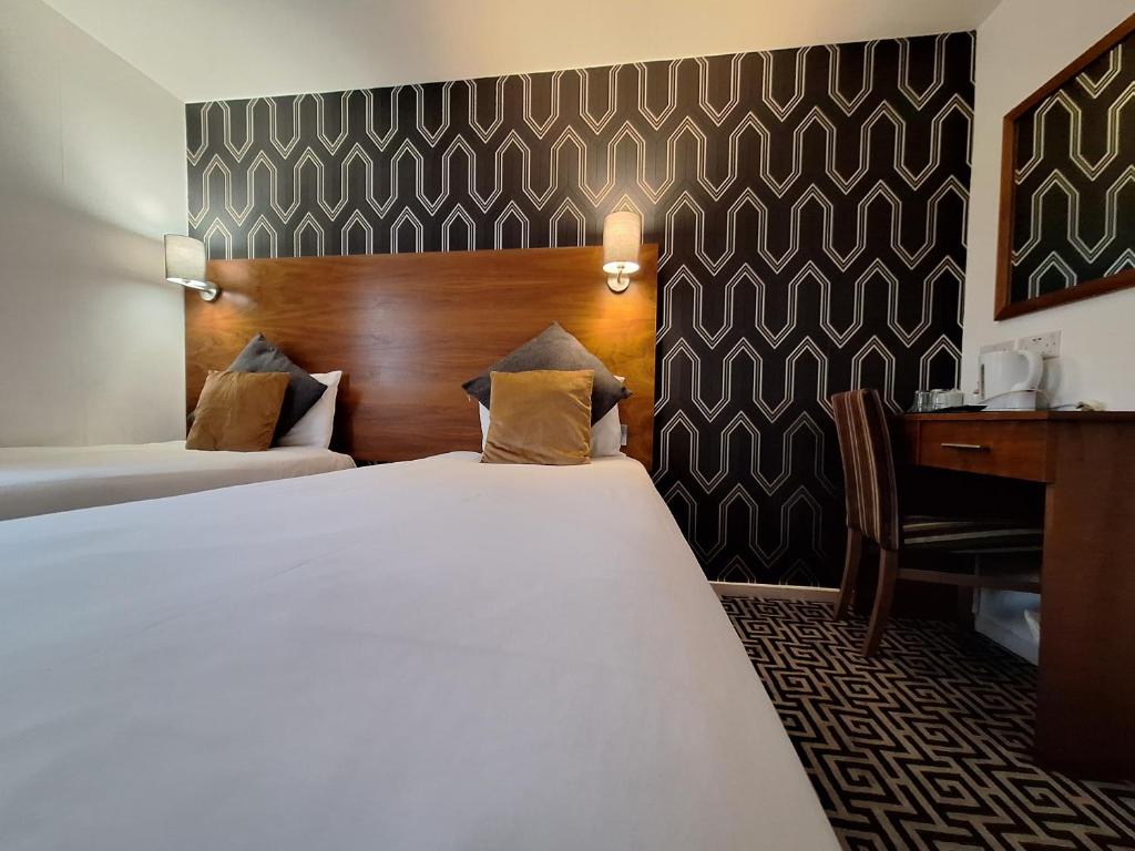 卢顿斯多克伍德酒店 - 卢顿机场的配有一张床和一张书桌的酒店客房
