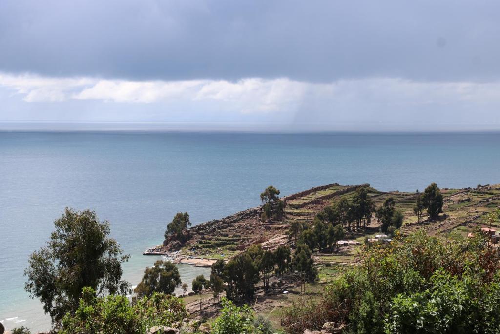 HuillanopampaWHITE SAND Taquile Lodge的从山丘上欣赏海景