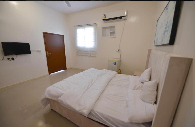 欧拉استراحة الضبيانية的卧室配有白色的床和窗户。