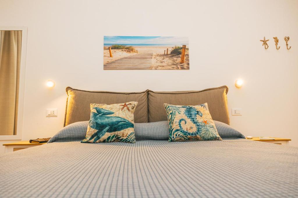 皮诺港Case Vacanze Il Sogno 2的一张带枕头的床和一张海滩景