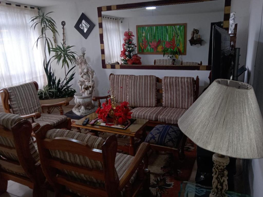 亚美尼亚Casa de Huéspedes en Armenia Quindío, Colombia的客厅配有椅子、桌子和台灯