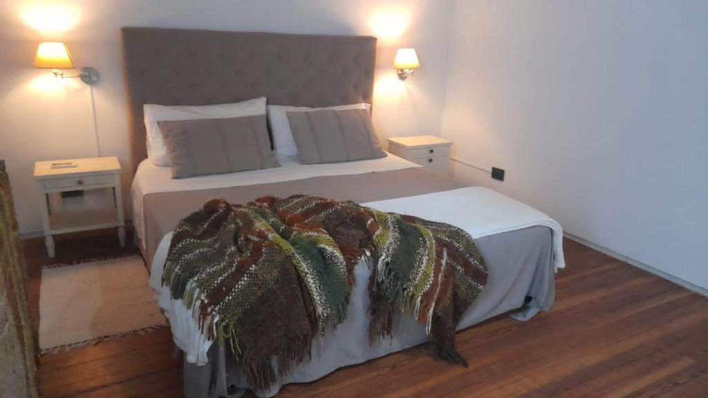 科洛尼亚-德尔萨克拉门托Las Glicinas Boutique Apartments的一间卧室配有一张大床,床上有毯子