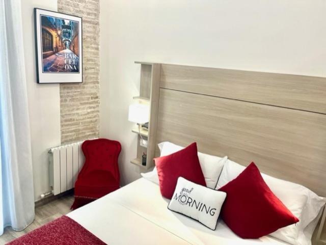 巴塞罗那Front Arc的一间卧室配有红色枕头和红色椅子。