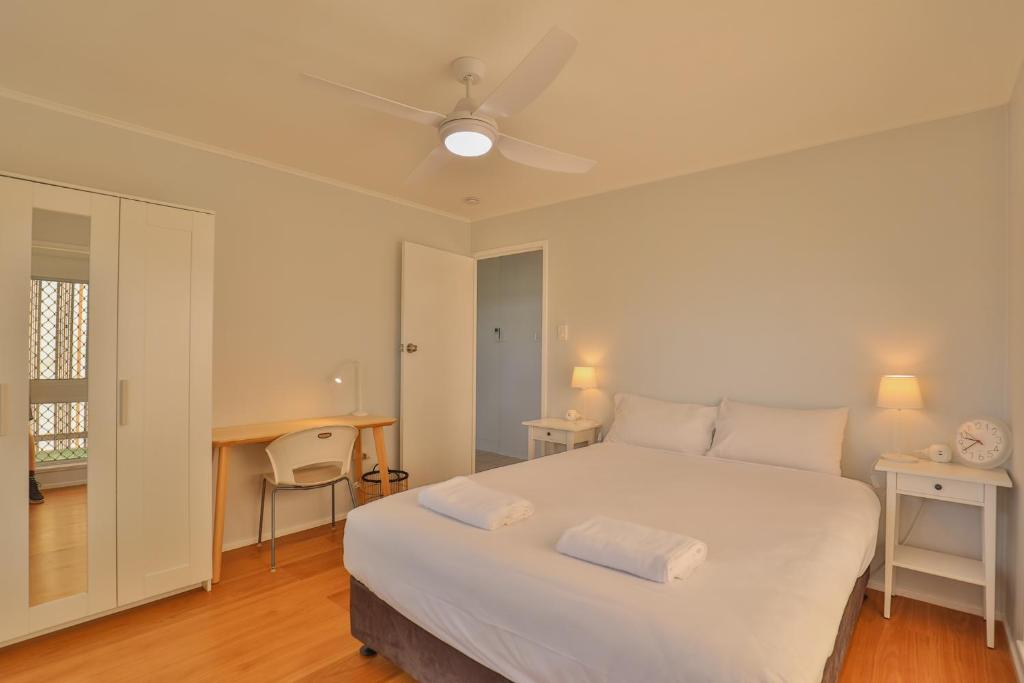 巴加拉Pacific Sun Bargara的卧室配有一张白色大床和一张书桌