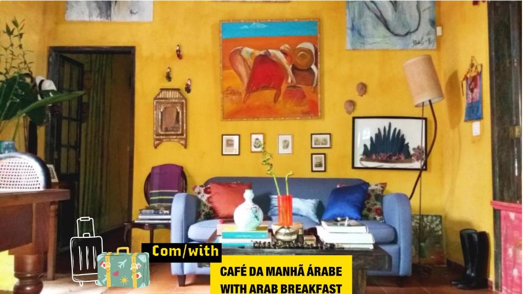 伊利亚贝拉Vila Santa Rosa的客厅设有蓝色的沙发和黄色的墙壁