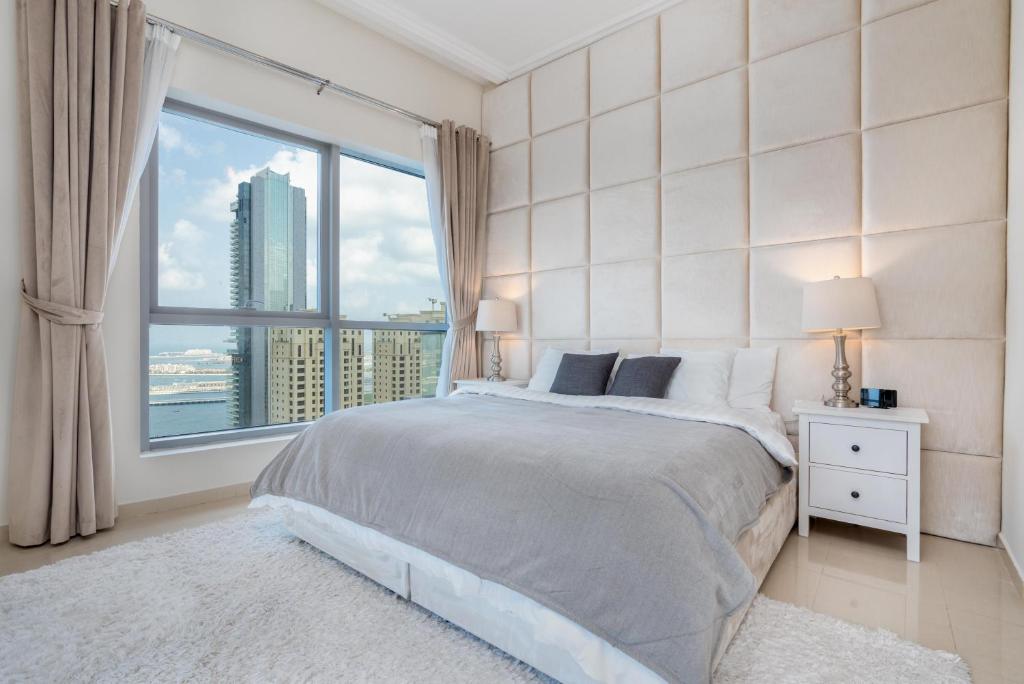 迪拜Perfect 2BD apartment in the heart of Marina - top spot的一间卧室设有一张床和一个大窗户