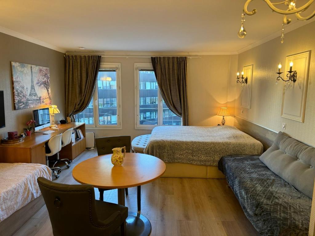 伊西莱穆利诺ALTAMIRA (Paris Expo - Porte de Versailles)的酒店客房设有两张床、一张沙发和一张桌子。
