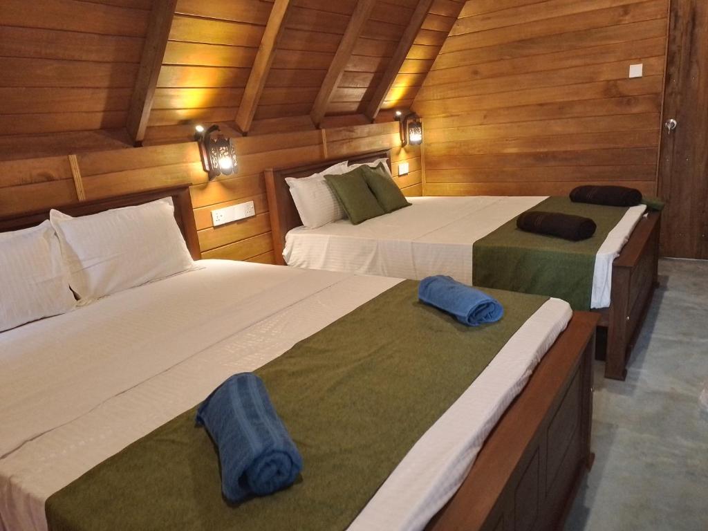 哈伯勒内Habarana New Star Homestay的木墙客房的两张床