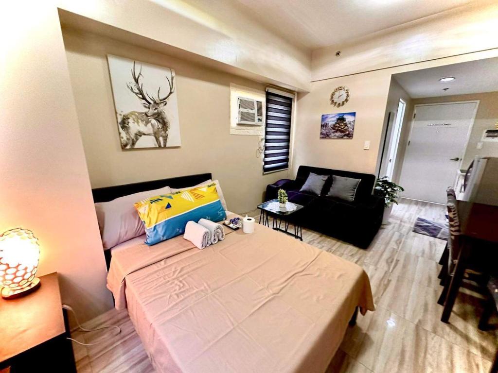 宿务Across Sm City Cebu Sunvida Tower Studio Unit的一个小客厅,配有一张床和一张沙发