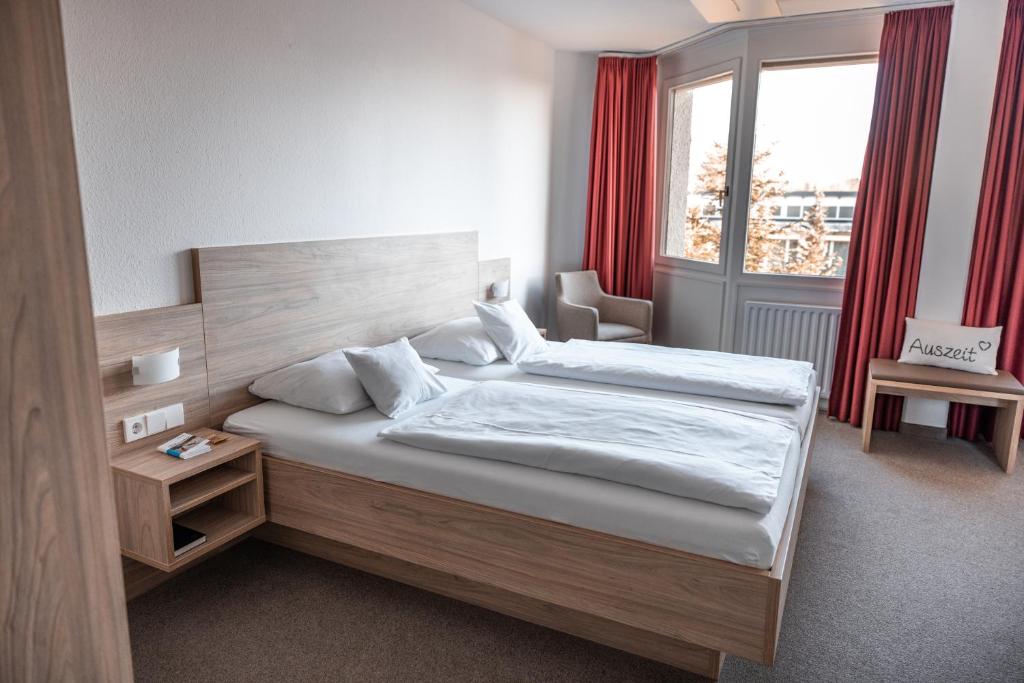 赫伦贝格Hotel am Schlossberg的一间卧室设有两张床和窗户。
