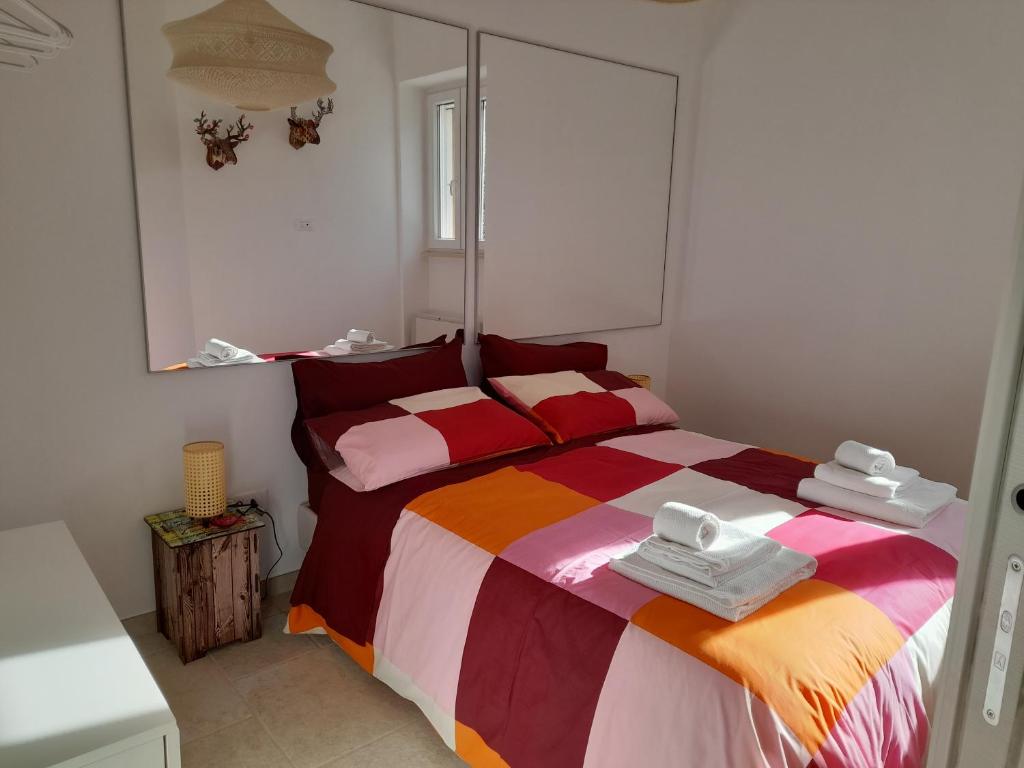 孔韦尔萨诺CASA VACANZA DONNA LINA的一间卧室配有一张带彩色毯子的床