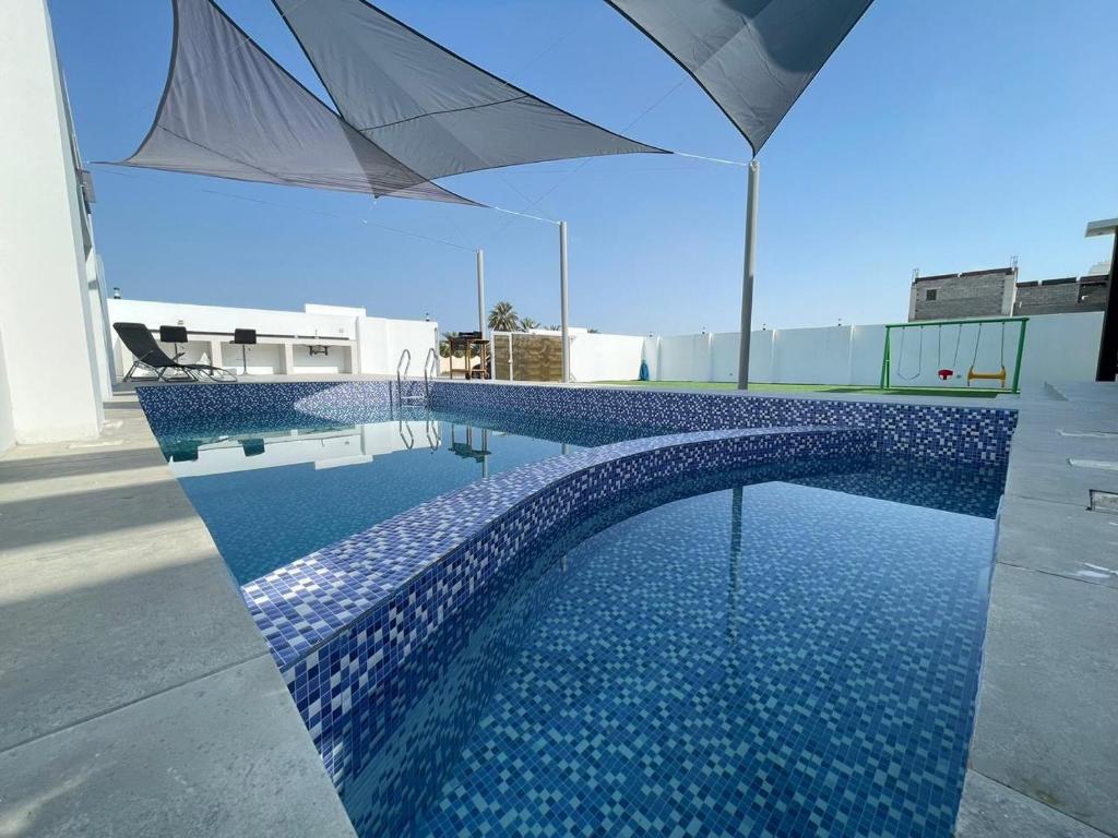 拜尔卡Bareeq Rest House的一座大楼顶部带遮阳伞的游泳池