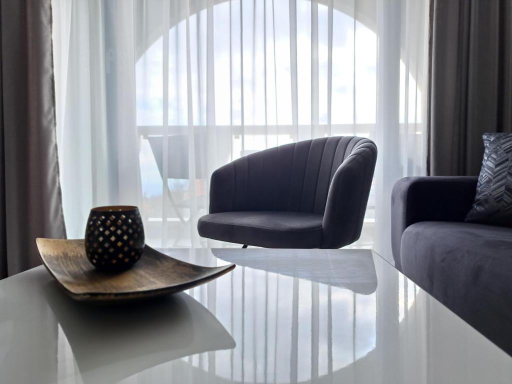 瓦尔纳LUXURY APARTMENT in Mediterranea VARNA Complex, sea view and Infinity pool的客厅配有椅子和桌子