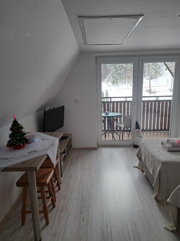 扎沃亚Zakątek DoriMaks的一间设有两张床的房间,里面有一棵圣诞树