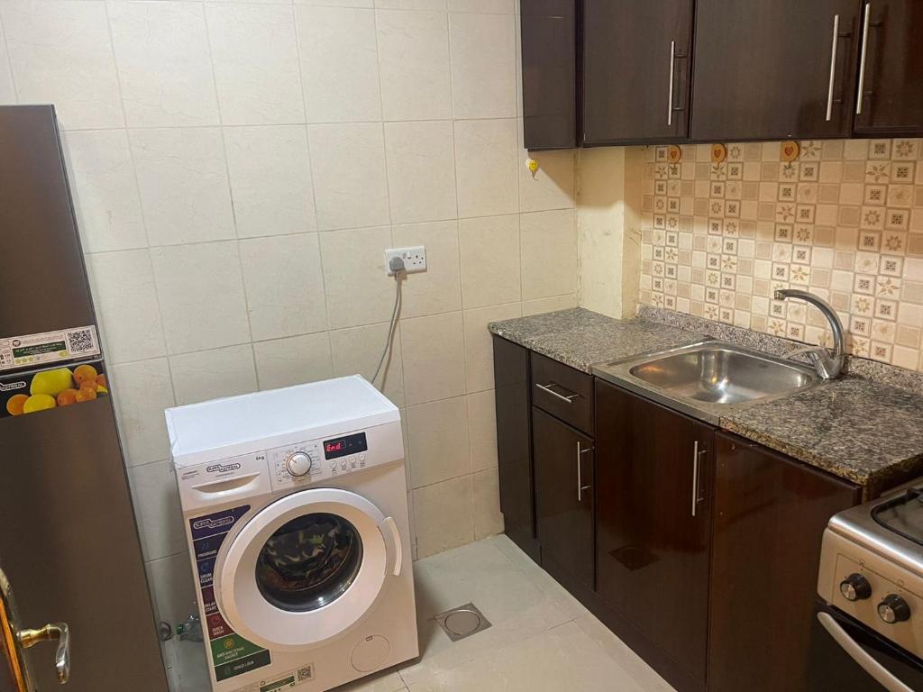 阿布扎比Studio R6的小厨房配有洗衣机和水槽