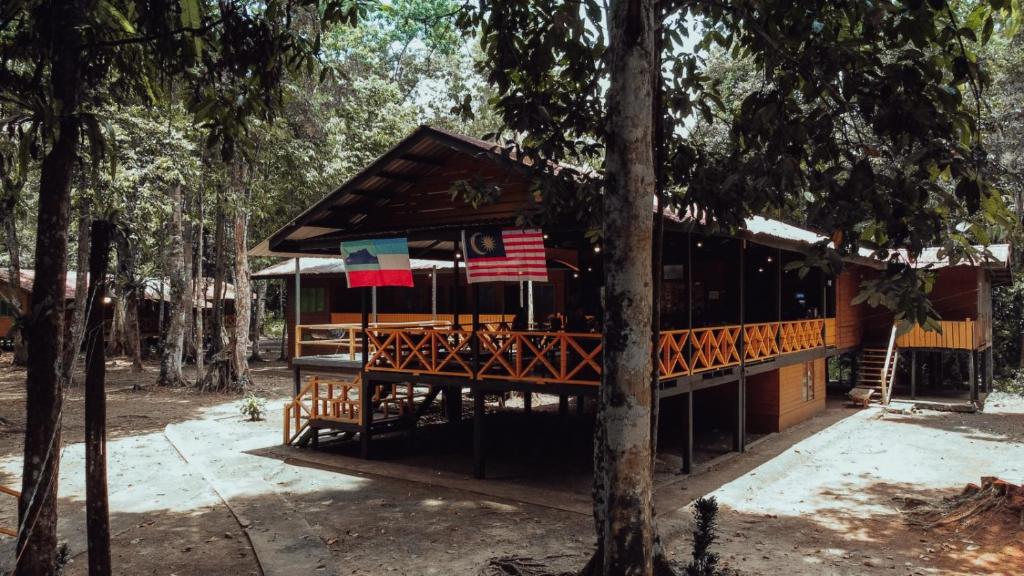 京那巴当岸Borneo Jungle Adventure的林中一座有美国国旗的建筑