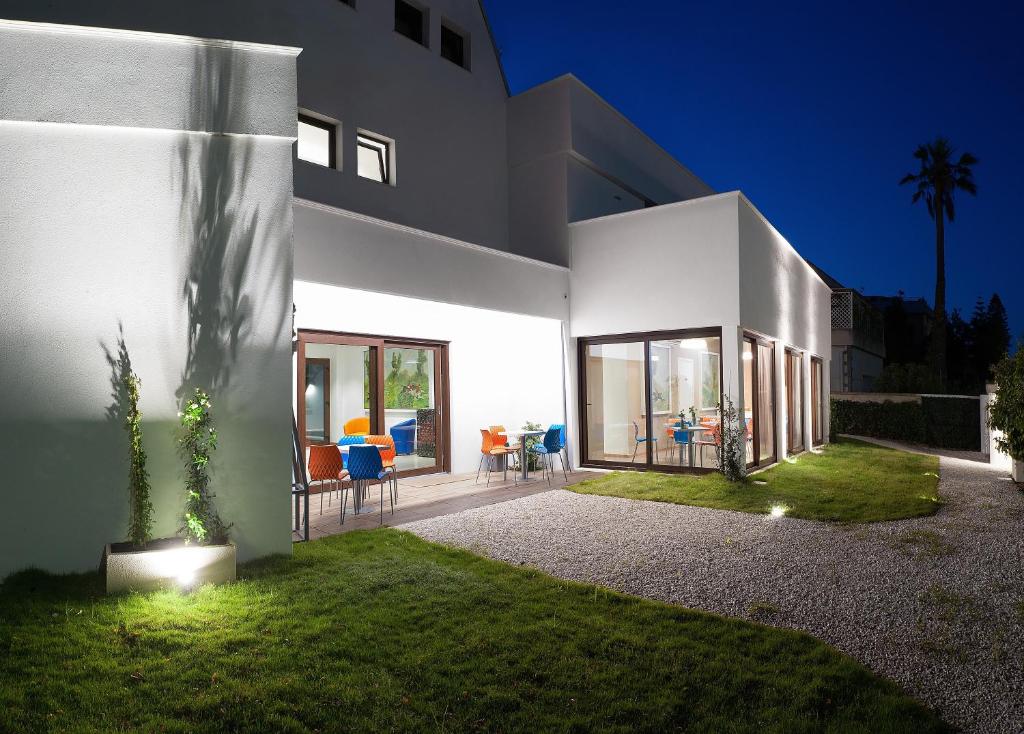 卡利亚里维拉斯维瓦酒店的大型白色房屋,设有庭院和草坪