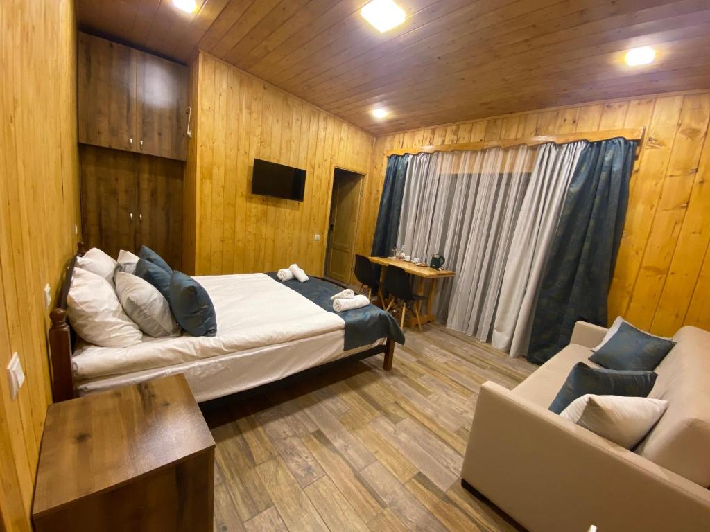 迪利然Haleb Hotel Complex的一间卧室配有一张床、一张沙发和一张桌子