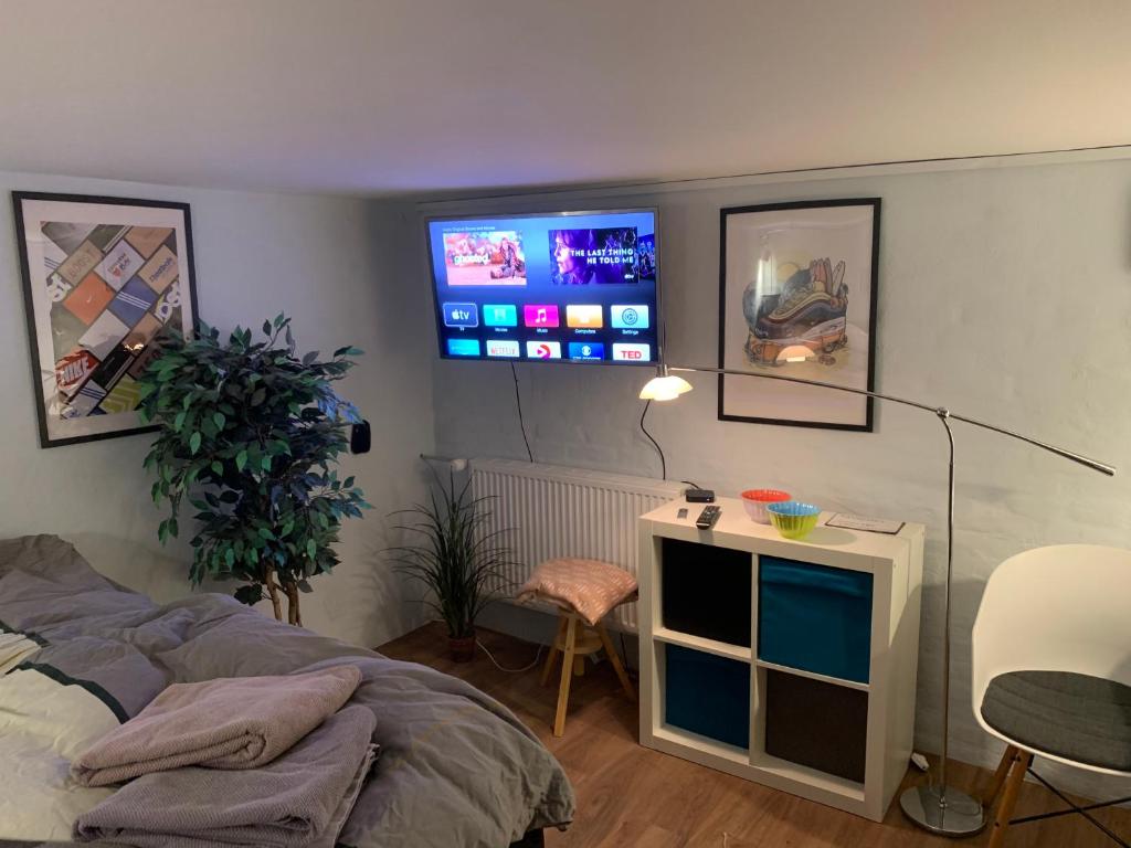 尼克宾法尔斯特Central by lejlighed的卧室配有一张床,墙上配有电视。