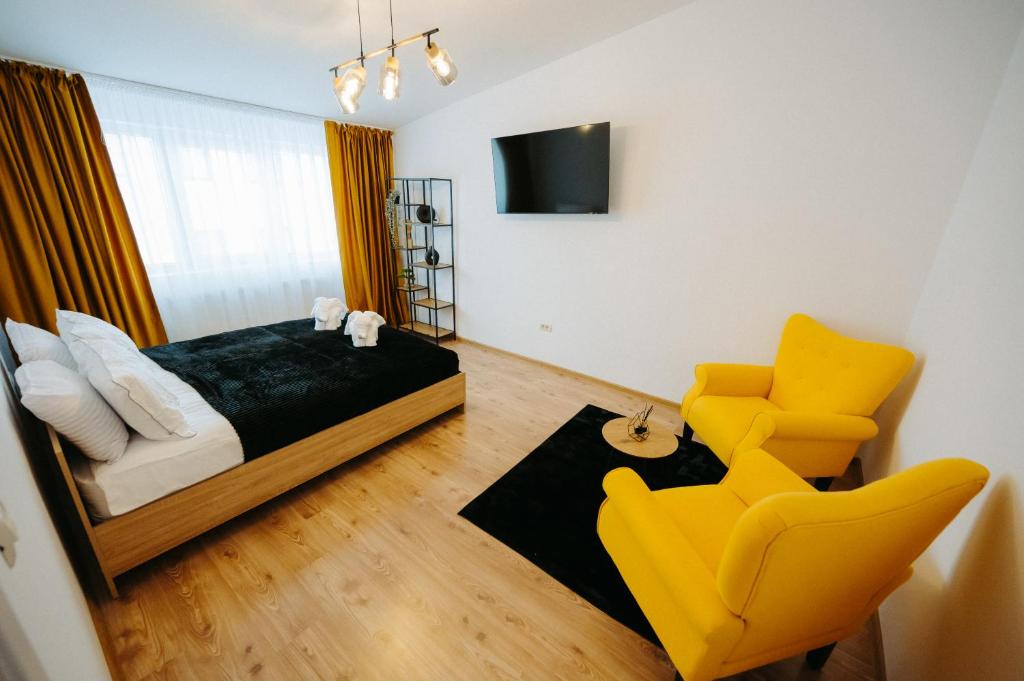 IpoteştiModern Studio的一间卧室配有一张床和一张黄色椅子