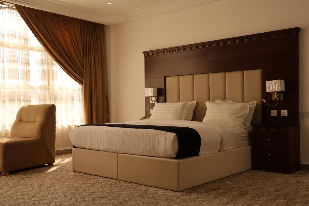 巴哈Al-faleh Hotel的一间卧室配有一张大床和一把椅子