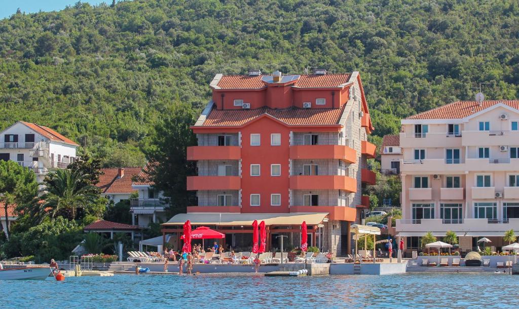 蒂瓦特Apart hotel Samardzic的水体上一座大型红色建筑