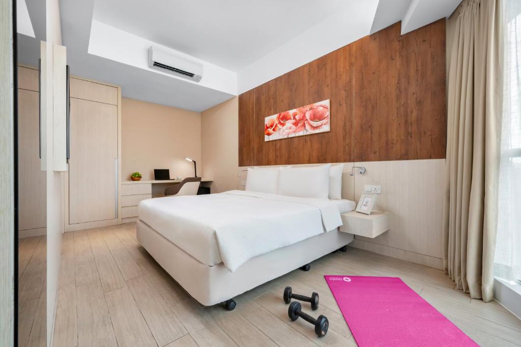 吉隆坡吉隆坡豪亚酒店式公寓 - 远东酒店集团旗下的卧室配有白色的床和粉红色地毯。