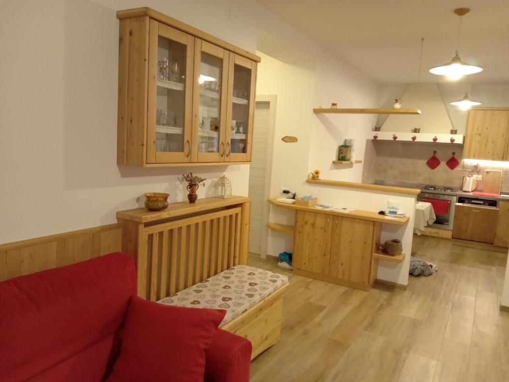 巴塞尔加·迪·皮纳Casa vacanze Insieme的一间带红色沙发的客厅和一间厨房