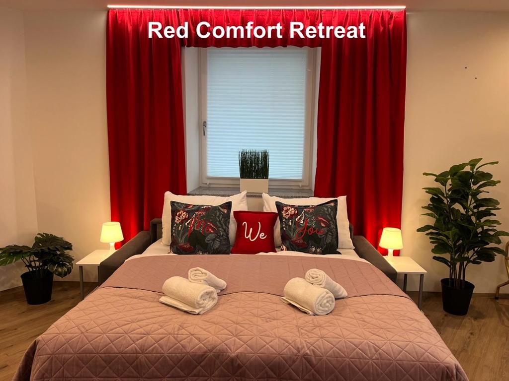 林茨Rudolfquartier Linz, Rudolfstraße的一张带红色窗帘和红色内容检索标志的床