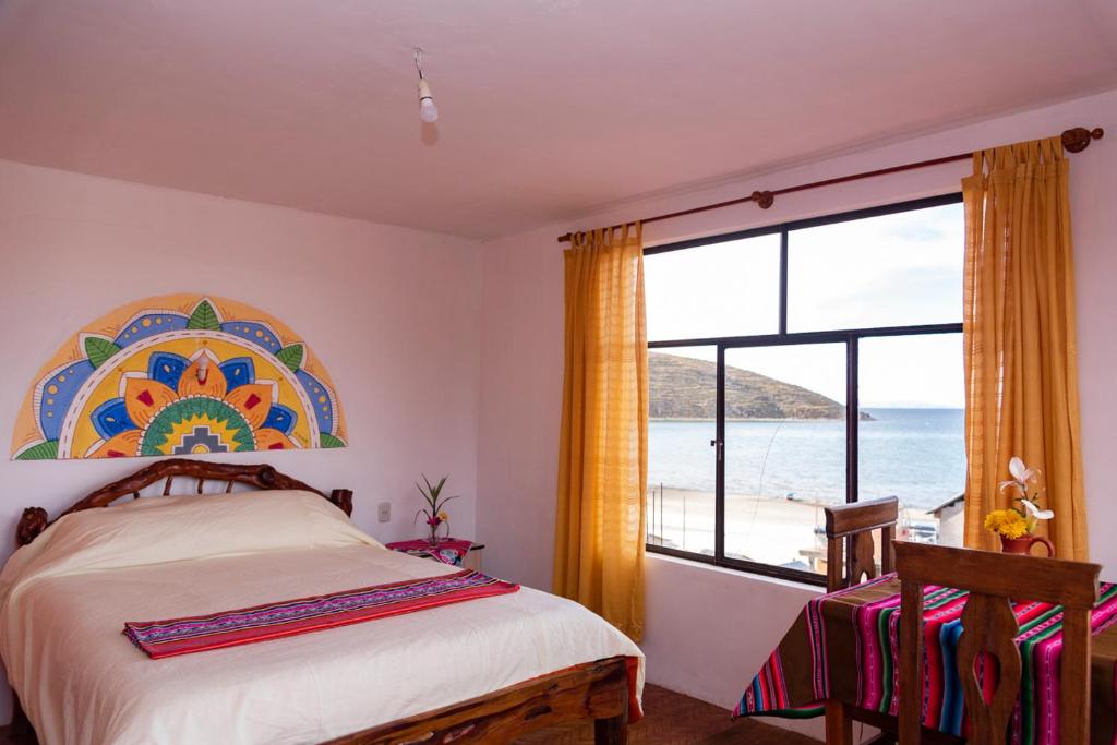 Comunidad ChallapampaHostal Margarita Isla del Sol Norte comunidad Challapampa的一间卧室配有一张床,享有海景