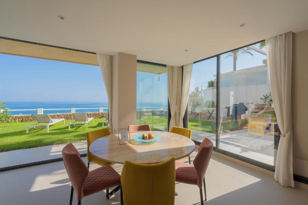多列毛利诺斯Seaside Tranquility and Urban Luxury - Stylish Duplex in Torremolinos w jacuzzi的一间带桌椅和大窗户的用餐室