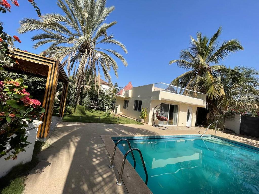萨利波图尔ParadisPlage, 1 min de la mer的一座带游泳池和棕榈树的房子